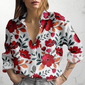 Könnte beinhalten: Weißes Button-Down-Hemd mit einem lebendigen Blumenmuster. Das Design zeigt große rote Blumen, grüne Blätter und orangefarbene Akzente. Das Hemd hat lange Ärmel und einen klassischen Kragen.