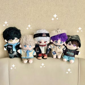 Puede incluir: Cinco mu&ntilde;ecos de peluche con varios peinados y atuendos. Los mu&ntilde;ecos tienen cabello negro, blanco, rubio y morado. Llevan chaquetas, petos y sombreros. Cada mu&ntilde;eco tiene ojos grandes y expresivos y ropa detallada.