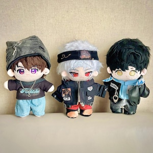 Puede incluir: Tres mu&ntilde;ecos de peluche con caracter&iacute;sticas de estilo anime. Los mu&ntilde;ecos tienen diferentes peinados, ropa y accesorios, incluyendo chaquetas, sombreros y collares. Los mu&ntilde;ecos son de varios colores, incluyendo negro, azul y gris.