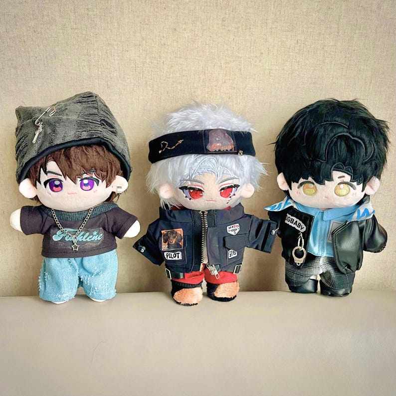 Puede incluir: Tres mu&ntilde;ecos de peluche con caracter&iacute;sticas de estilo anime. Los mu&ntilde;ecos tienen diferentes peinados, ropa y accesorios, incluyendo chaquetas, sombreros y collares. Los mu&ntilde;ecos son de varios colores, incluyendo negro, azul y gris.