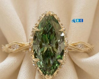 May include: A gold ring featuring a large marquise-cut green gemstone as the center stone, surrounded by a halo of small clear stones. The band has an intricate, textured, woven metal design with small clear stones embedded along the sides.