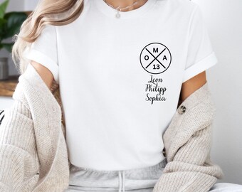 May include: White t-shirt with a black circle logo that says "M O A 13" and the names Leon, Philipp, and Sophia underneath.