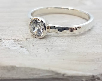 Hammered engagement ring in recycled 9ct white gold with a conflict free diamond.