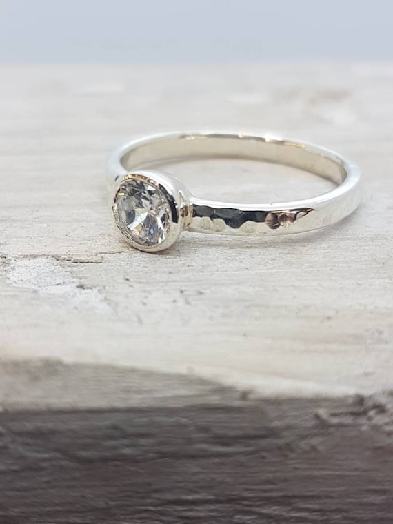 Hammered engagement ring in recycled 9ct white gold with a conflict free diamond.