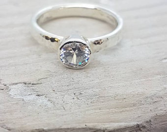 Recycled, 9 ct white gold, hammered band, set with a 5 mm diamond. 3 mm wide