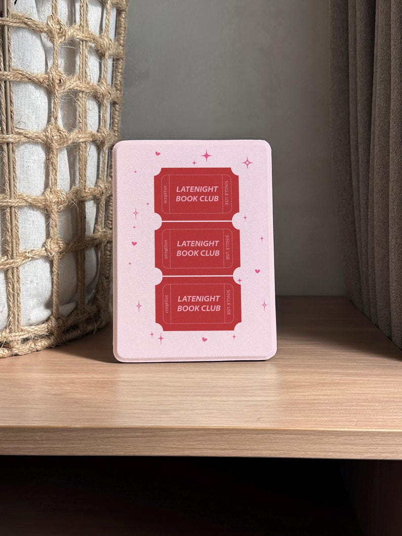 vintage and vibrant Kindle case featuring a soft pink background with three bold red ticket-style designs labeled “LATENIGHT BOOK CLUB” and marked “SINGLE USE.” Decorative pink hearts and sparkles add a whimsical, cozy vibe—perfect for book lovers who enjoy getting lost in stories after dark.