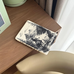 Puede incluir: Un cuaderno ilustrado en blanco y negro con un vaquero montando a caballo por un bosque. La portada del cuaderno tiene el texto "Nancy's Notes" en la esquina inferior derecha.