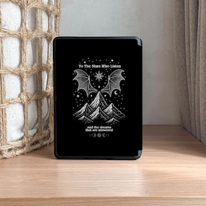 K&ouml;nnte beinhalten: Schwarze Tablet-H&uuml;lle mit einer wei&szlig;en Grafik, die Berge, Sterne und ein fledermausartiges Fl&uuml;geldesign zeigt. Der Text lautet "To The Stars Who Listen" und "and the dreams that are answered."