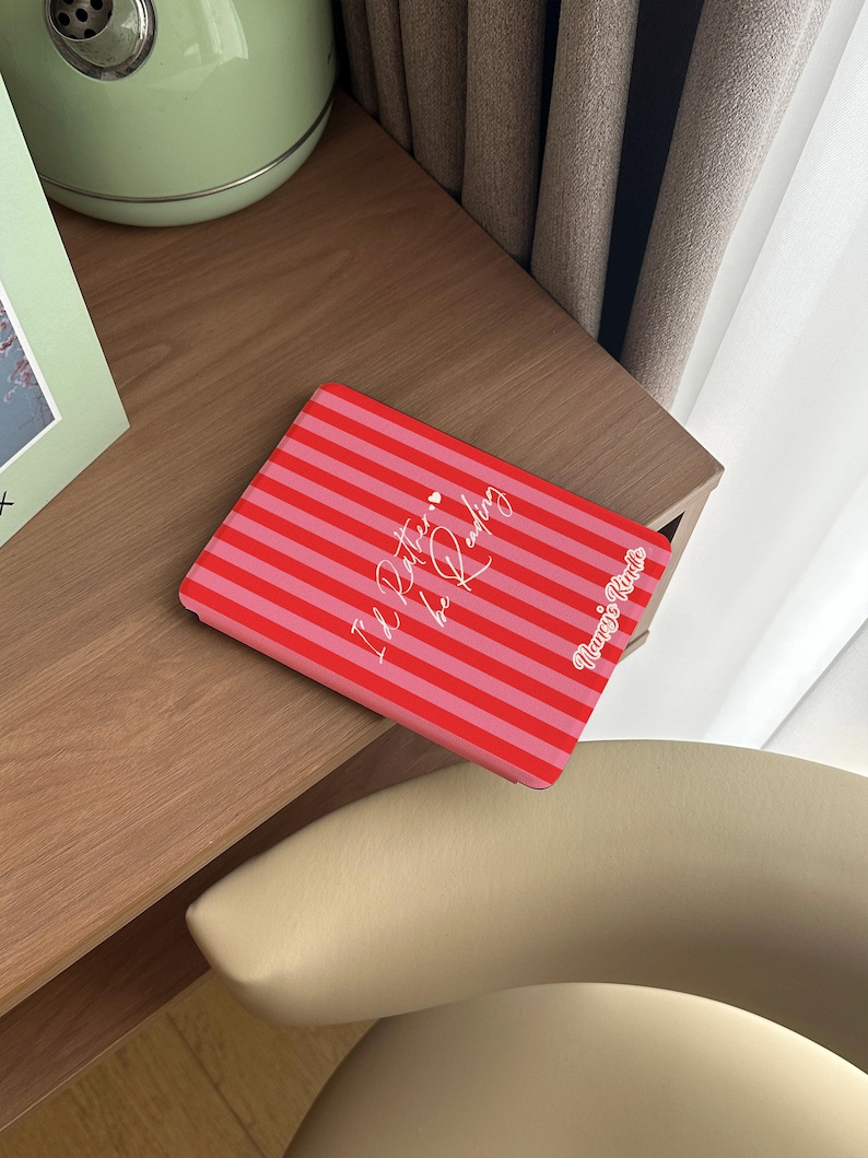 Red and pink striped Kindle case with handwritten-style script that reads “I’d Rather be Reading,” accented by two tiny hearts — a sweet and sassy nod to every book lover’s true priorities. A heartfelt gift for the friend who always sneaks a novel into their bag, your favorite coworker who reads on their lunch break, or anyone who’d rather be curled up with a good story than doing literally anything else. Perfect for Valentine’s Day, Galentine’s Day, or just because they deserve a little joy.