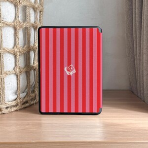 May include: A red and pink striped e-reader cover with a small white book icon in the center.