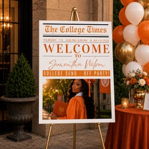 May include: A white rectangular event sign on a gold easel featuring the text The College Times, Welcome to Samantha Wilson, and College Send-Off Party. It includes a photograph of a graduate in an orange gown holding a diploma.