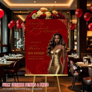 Op de afbeelding: Een rood welkomstbord op een gouden ezel, versierd met bloemstukken. Het bord luidt "A Night of Glamour & Elegance" en verwelkomt gasten op Thalia's 30e verjaardag op 23 augustus 2025. Een vrouw in een gouden jurk is afgebeeld.
