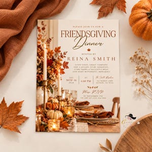 May include: A rectangular Friendsgiving dinner invitation card featuring a warm autumn table setting with lit candles, pumpkins, and fall foliage. The text reads: Please join us for a Friendsgiving Dinner hosted by Reina Smith, Saturday Nov 16 2026.