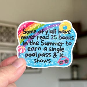 May include: A colorful sticker with a rainbow, beach ball, sunglasses, and a donut. The sticker reads, "Some of y'all have never read 25 books in the Summer to earn a single pool pass & it shows."