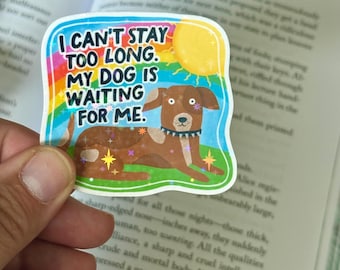May include: A colorful sticker with the text "I CAN'T STAY TOO LONG. MY DOG IS WAITING FOR ME." features a cartoon dog on a green lawn with a yellow sun and rainbow accents. The sticker is held in a hand.