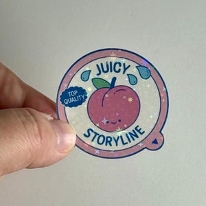 May include: A circular sticker with a pink peach illustration and the words "JUICY STORYLINE." The sticker has a holographic effect and features a blue "Top Quality" badge and water droplet graphics.