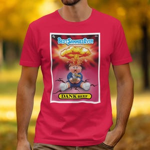 May include: Red t-shirt featuring a cartoon graphic in a white border. The graphic shows a baby with an explosion above its head, with the text "Best Sammies Ever" and "Dank Beef".
