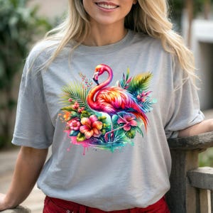 May include: A gray t-shirt with a colorful flamingo standing in a pool of water surrounded by tropical flowers and leaves.