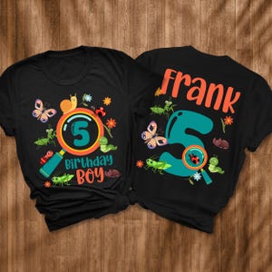May include: Black t-shirts with a colorful insect-themed design. One shirt features a magnifying glass with the number 5 and the words "Birthday Boy." The other shirt has the name "Frank" and the number 5.