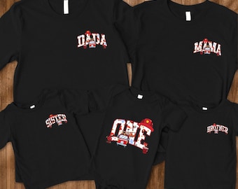 Peut inclure: Des t-shirts noirs avec des motifs de pompiers. Les chemises présentent les mots "DADA", "MAMA", "SISTER", "ONE" et "BROTHER" en rouge et blanc, avec un motif de pompier.