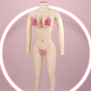 Op de afbeelding: Een huidkleurig bodysuit met een roze bikinitop en -broekje. De bikini is gemaakt van een sprankelend, getextureerd materiaal. De bodysuit wordt gepresenteerd op een witte sokkel tegen een roze achtergrond.