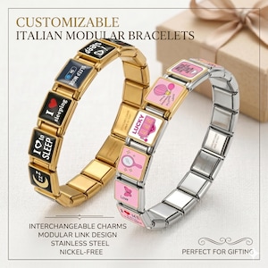 Pode incluir: Duas pulseiras modulares italianas personalizáveis. Uma é dourada com berloques pretos e brancos, a outra é prateada com berloques rosa e branco. Os berloques apresentam vários ícones e as palavras "sleep" e "lucky". As pulseiras são feitas de aço inoxidável.