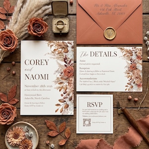May include: A wedding invitation suite featuring a main card, details card, and RSVP card with floral illustrations in rust and brown tones. Includes a rust-colored envelope with a gold wax seal, a gold ring box with a ring, and dried flowers.