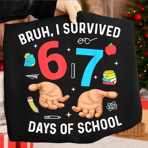 Op de afbeelding: Zwart t-shirt met de tekst "BRUH, I SURVIVED 6-7 DAYS OF SCHOOL." Het ontwerp bevat een rode "6", een blauwe "7" en illustraties van schoolspullen zoals een rugzak, boeken en een potlood.