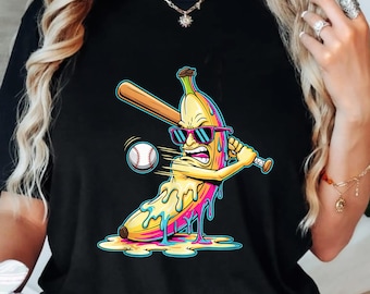 May include: Black t-shirt with a cartoon banana wearing sunglasses and hitting a baseball with a bat. The banana is yellow with colourful dripping accents. The baseball is white with red stitching.