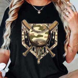May include: Black t-shirt with a baseball graphic in a camouflage design. The baseball is set over a home plate shape, with two crossed baseball bats behind it. The baseball has a melting effect, with dripping details.