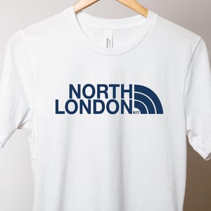May include: White t-shirt with a navy blue graphic that says "NORTH LONDON N17" with a stylized mountain range graphic.