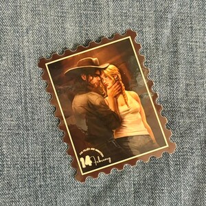 May include: A brown and white vintage-style stamp with a couple embracing. The stamp has a scalloped border and the text "For Fillies and Monsters 14 February".