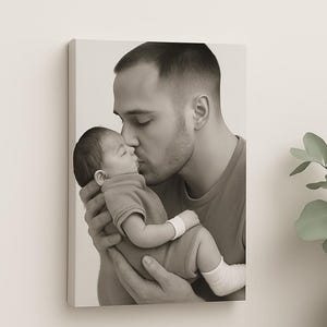 Puede incluir: Impresi&oacute;n en lienzo en tonos sepia que muestra a un hombre besando a un beb&eacute;. El beb&eacute; lleva un body de color claro. El hombre lleva una camiseta. La imagen est&aacute; montada en una pared blanca.
