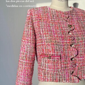 May include: A pink and white tweed jacket with heart-shaped buttons. The jacket is cropped and has long sleeves. The image includes a size chart with measurements in inches. The text "Podras combinar diferentes tallas de chaqueta y short. Los patrones de ambas piezas se venden por separado. LYDIA MAROTO Fashion pattern | digital course" is also included.