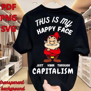 May include: Black t-shirt featuring a cartoon dwarf with a red hat and jacket, arms crossed. The text "THIS IS MY HAPPY FACE" is above the dwarf, and "JUST VIBIN THROUGH CAPITALISM" is below. The image also includes "PDF", "PNG", and "SVG" text.