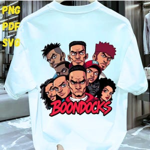 May include: White t-shirt featuring a cartoon graphic of several characters with stern expressions. The word "BOONDOCKS" is written in red script across the bottom. The shirt has short sleeves and a crew neck.
