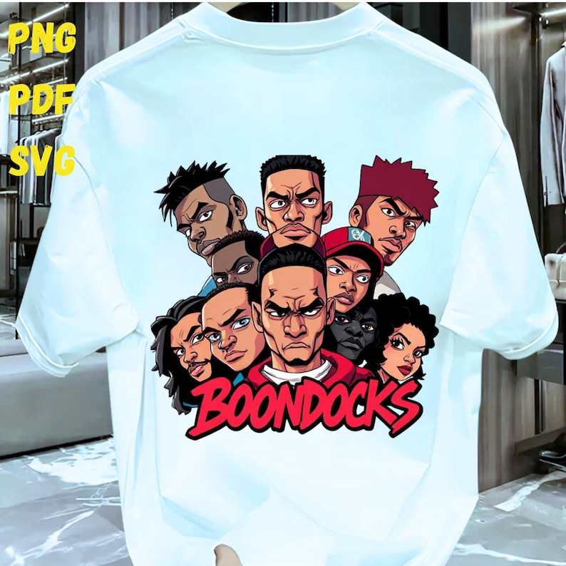 May include: White t-shirt featuring a cartoon graphic of several characters with stern expressions. The word "BOONDOCKS" is written in red script across the bottom. The shirt has short sleeves and a crew neck.