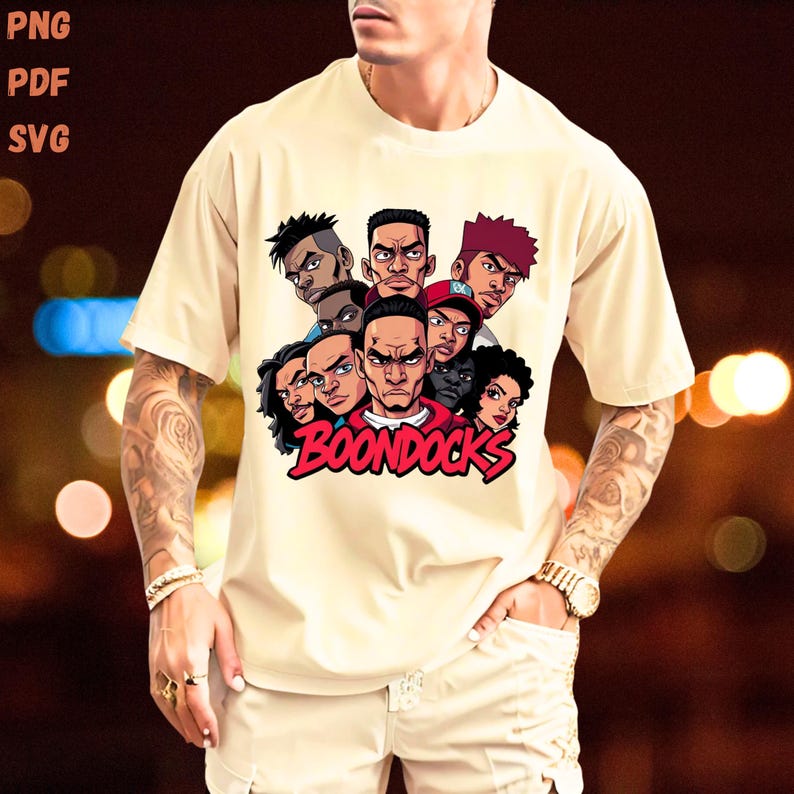 May include: Cream-colored t-shirt featuring a graphic of several cartoon characters with various skin tones and hairstyles. The word "BOONDOCKS" is printed in red, stylized lettering below the characters. The shirt has short sleeves and a relaxed fit.