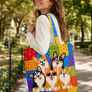 May include: A tote bag featuring a colorful patchwork design with a grid of squares in red, orange, yellow, green, blue, and purple. The bag displays five cartoon Corgi dogs, one wearing heart-shaped sunglasses, against the patterned background.