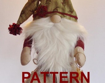 May include: A fabric gnome doll featuring a long white faux fur beard, a tan nose, and a pointed olive green hat with a dark red pom-pom and trim. The doll has tan fabric hands and a tan body. The word PATTERN is printed in large red letters.
