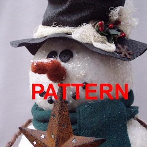 Puede incluir: Una figura de muñeco de nieve con un sombrero de copa negro con adornos de fibra blanca, bayas rojas y una pequeña estrella de metal. El muñeco tiene una superficie blanca texturizada, ojos de botón negros y una nariz color óxido. Texto: PATTERN Happy Valley Primitives PDF Pattern Not a finished tree topper.