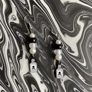 El amor es veneno, juego de pendientes colgantes.