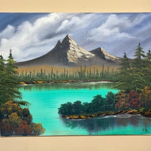 Bob Ross inspired landscape oil painting with mountain and river scene using bright colors on a 16 x 20 stretched canvas.