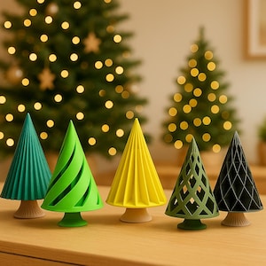 May include: A collection of five decorative Christmas trees in various colors, including green, yellow, and black. Each tree has a unique design, with some featuring ribbed or lattice patterns. The trees are displayed on a wooden surface.