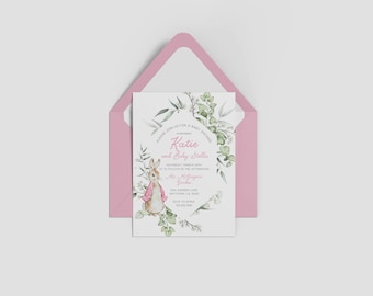 May include: A white baby shower invitation with a watercolor illustration of a rabbit wearing a pink dress and surrounded by green leaves. The text on the invitation reads "Please join us for a baby shower for Katie and Baby Stella".