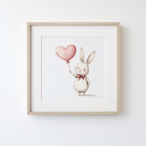 Puede incluir: Un conejo blanco sosteniendo un globo rosa en forma de coraz&oacute;n con un lazo rojo. El conejo est&aacute; de pie sobre un fondo blanco.