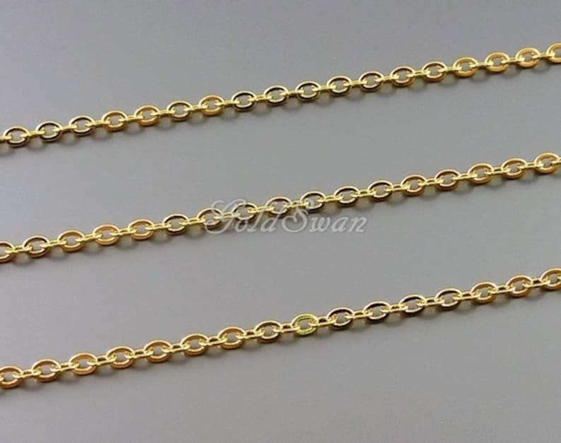 May include: Gold chain with oval links. The chain is shown in three rows on a gray background.