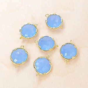 May include: Six gold-toned metal connector charms with light blue faceted glass round inserts. Each charm has two jump rings for attaching to jewelry.