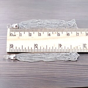 Peut inclure: Deux glands en cha&icirc;ne argent&eacute;e, mesurant chacun environ 18 cm de long, sont pr&eacute;sent&eacute;s sur un fond en bois. Une r&egrave;gle est utilis&eacute;e pour montrer la longueur des glands.