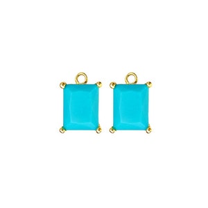 May include: A pair of gold-toned earring charms with turquoise blue square-shaped stones.